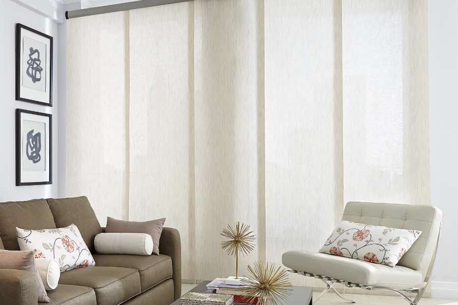 Light-filtering window shades offer some privacy without completely blocking lovely natural light. White translucent shades on a tall living room window