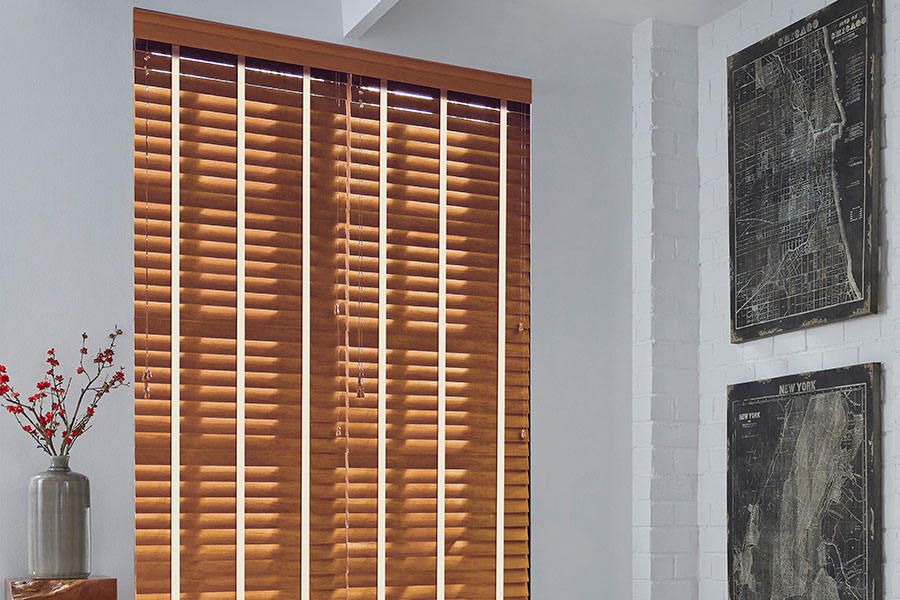 Light faux wood blinds make a bold decor statement in your home. Light faux wood blinds in a corner of a kitchen