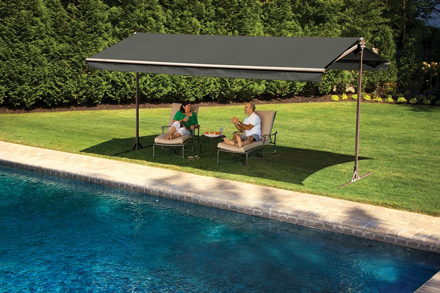 Put your freestanding awning anywhere to create a shady oasis in your yard. Two people lounging beside a pool under a freestanding awning