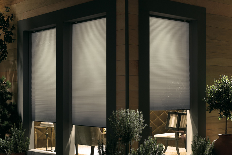 Cellular shades are modern and stylish window treatments for your home in Las Vegas. Dark gray cellular shades displayed from the exterior of a home.