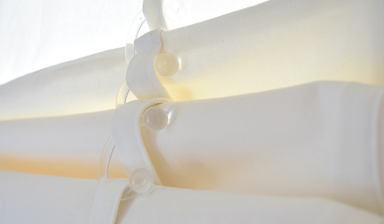 The innovative hook system let you set your tumble shade at different heights. close up of white rolled tumble shades